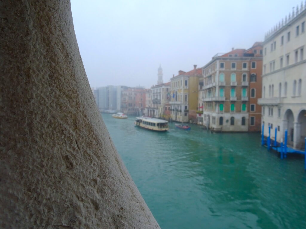 A View Of The Grand Canal From Rialto Bridge With A Boat On The Water